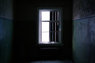 Dark room with half shutered window letting in light