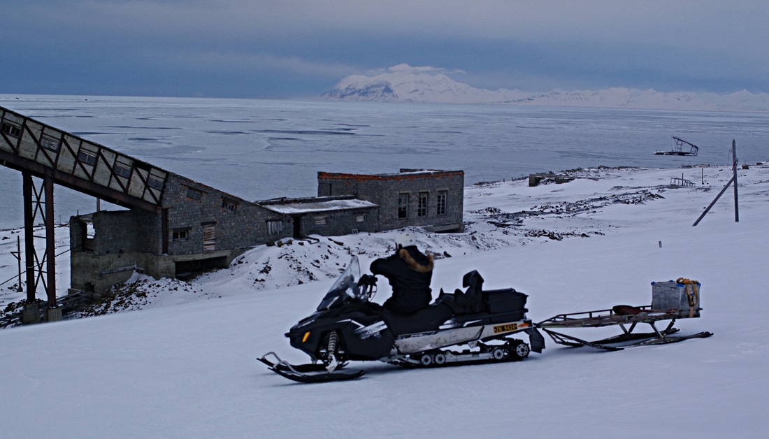 man on snowmobile looking out over Colesbukta