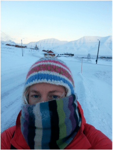 Researcher barely visible through layers of hats and scarves